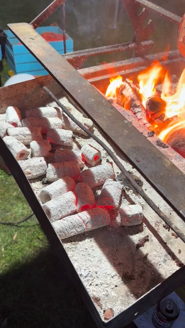 De houtskool wordt aangestoken en op temperatuur gebracht